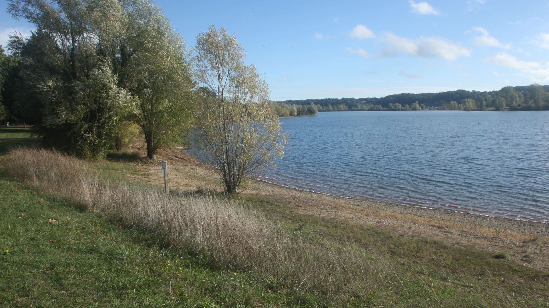 La plage et la rive du lac de Saint-Cyr à Beaumont Saint-Cyr, sous un ciel dégagé