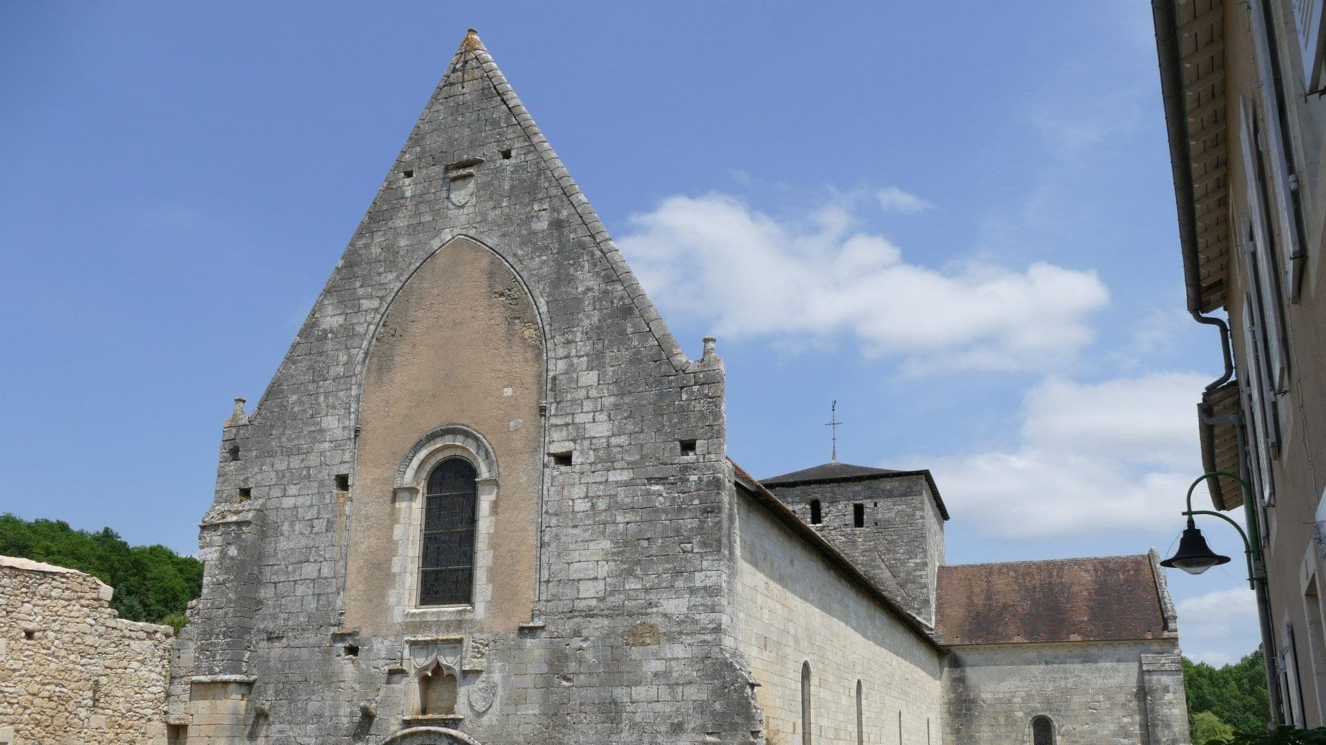 L'abbatiale Notre-Dame de Fontaine-le-Comte, pignon et clocher se détachant sur le ciel
